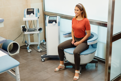 woman sitting in an emsella chair