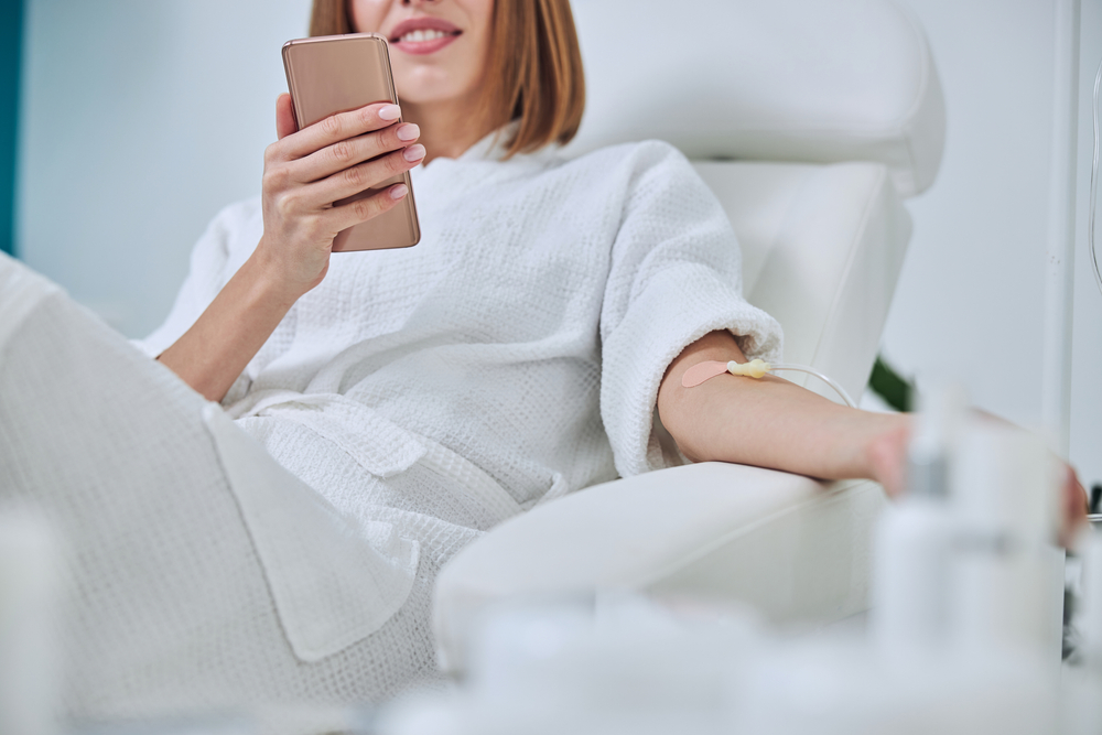 woman sitting in a chair getting iv nutrient therapy