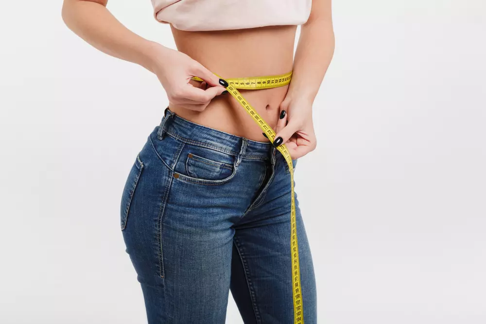 woman measuring her waist