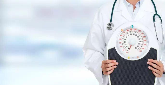 doctor at weight loss clinic holding scale