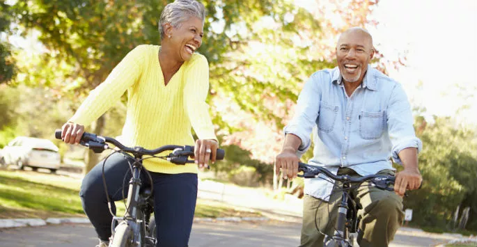 couple riding bikes through a park