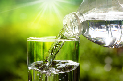 water being poured into a glass from a bottle